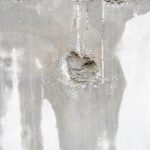 Mur interieur abime avec des traces d humidite, un enduit cloque et une zone de platre creusee