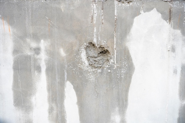 Mur interieur abime avec des traces d humidite, un enduit cloque et une zone de platre creusee